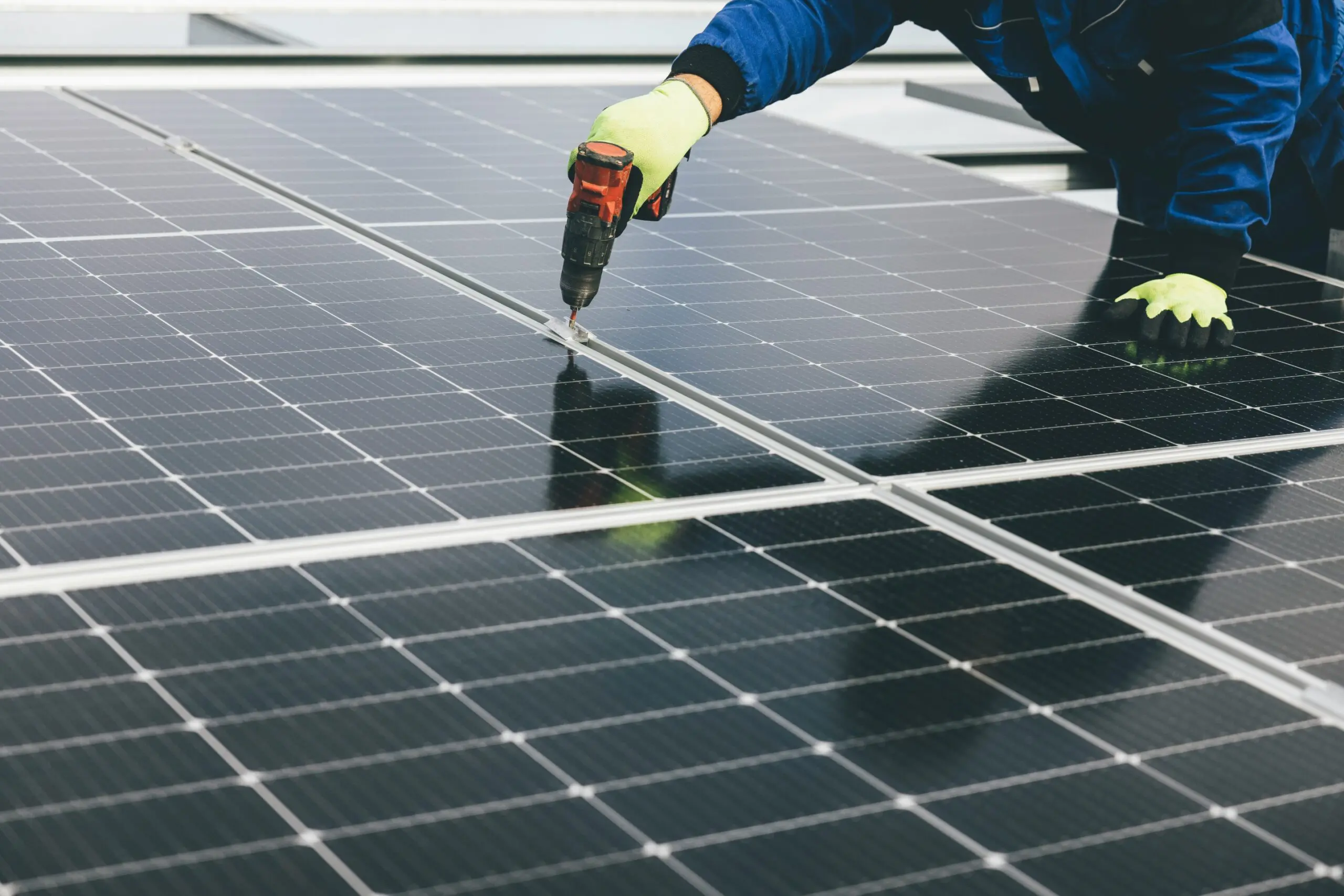 Ein Monteur befestigt ein Photovoltaikmodul an einer Unterkonstruktion.