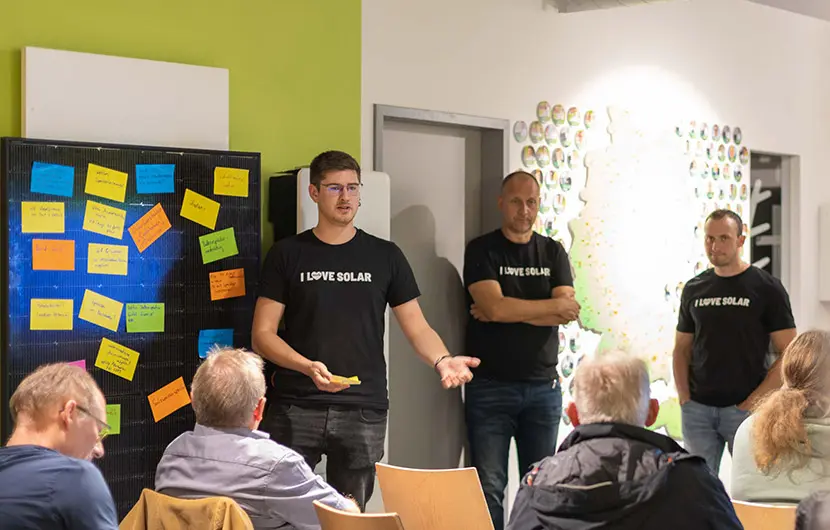 Ein Photovoltaik Spezialsit spricht zu einer Menge von Zuschauern auf einer Infoveranstaltung