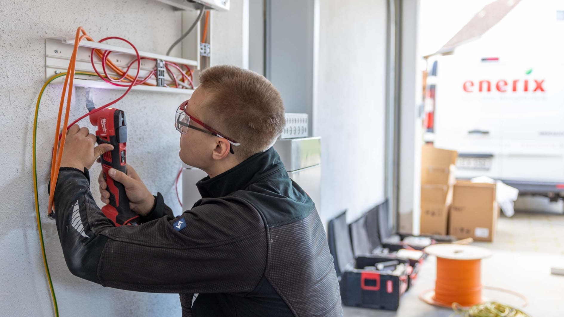 Ein Elektriker von enerix arbeitet in einer Garage und bereitet eine Speichernachrüstung vor.