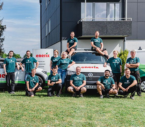 Das Team von enerix Nord-Ostsee, enerix Flensburg und enerix Pinneberg steht vor einem enerix Fahrzeug und einem enerix Schild.