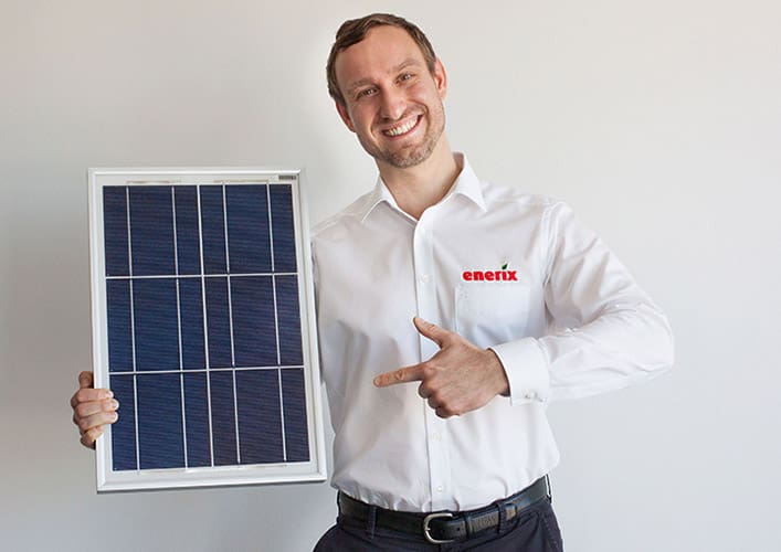 Matthias Kögel - enerix Frankfurt hält Solarmodul in der Hand