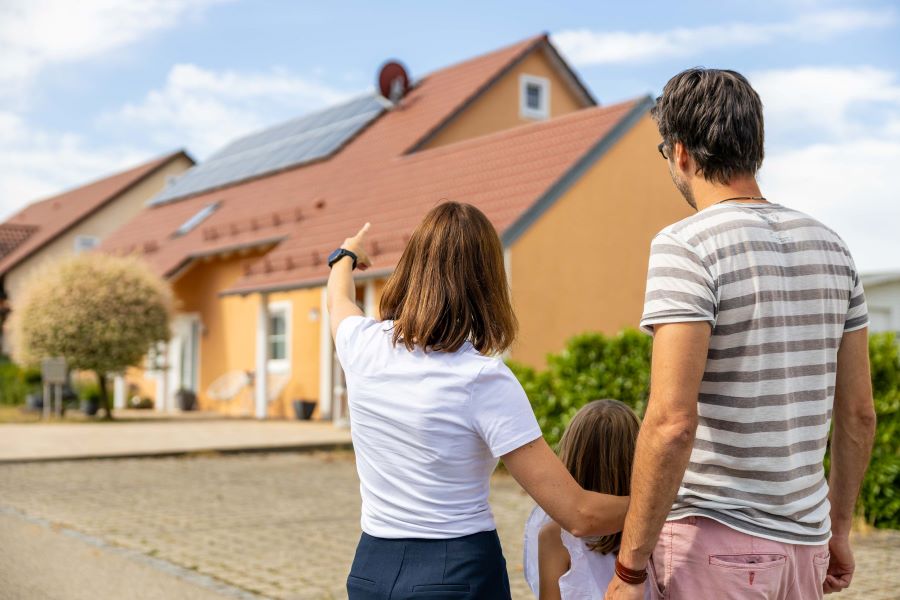 Eine Familie vor einem Haus mit einer Photovoltaikanlage
