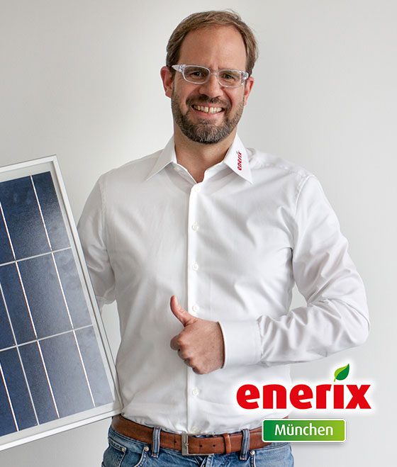 Jürgen Kastner von enerix München hält ein Solarmodul in der Hand
