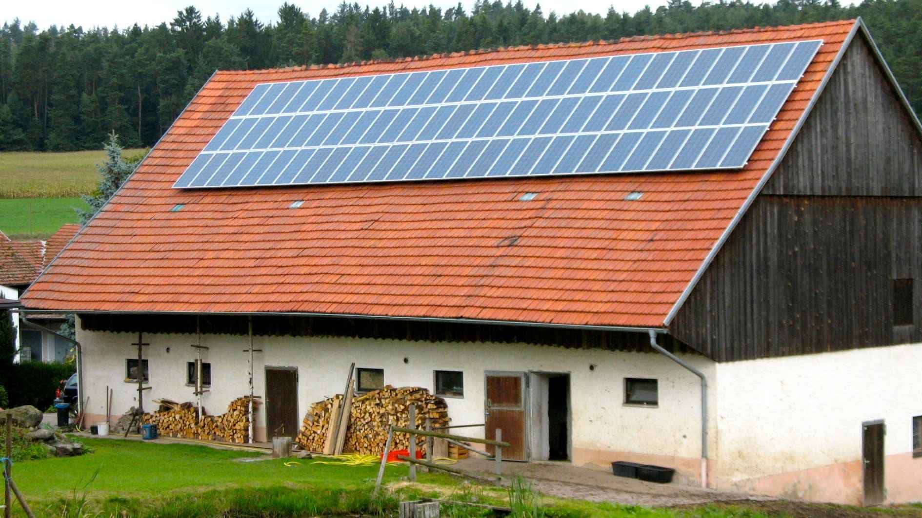 Eine Photovoltaikanlage auf einem großen Dach von einer Scheune.