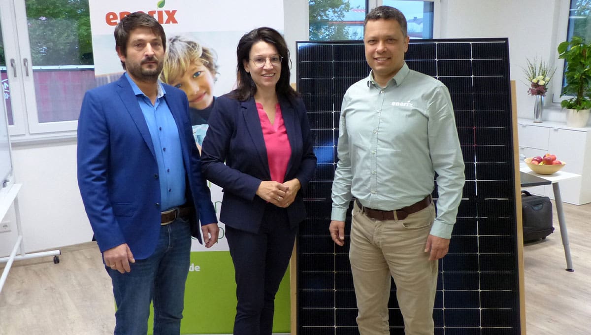 mdB Martina Engelhardt, Gerhard Wegmann von enerix Cham und Bürgermeister Martin Bauer stehen im Büro von enerix Cham vor einem Photovoltaikmodul.