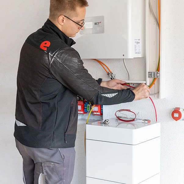 Ein Elektriker von enerix arbeitet an einem Wechselrichter.