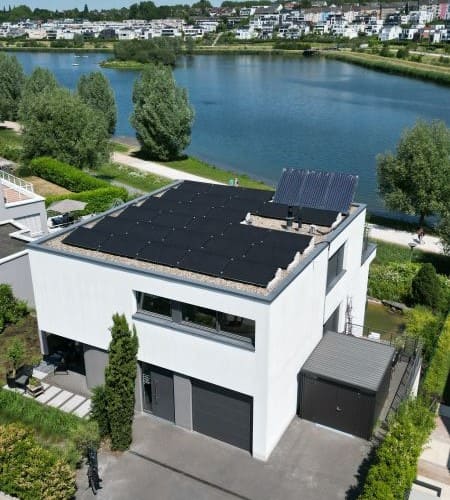 Ein Haus mit einem Flachdach, als Smart Energy Home mit einer Photovoltaikanlage auf dem Dach
