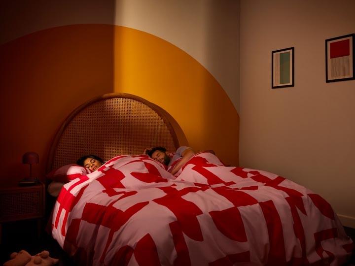 Ein junges Paar liegt in einem Bett in einem warmen Raum und schläft