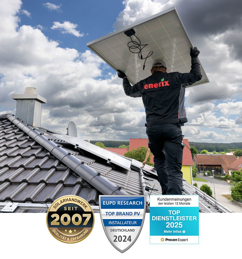 Ein Monteur steht auf einem Dach und trägt ein Solarmodul