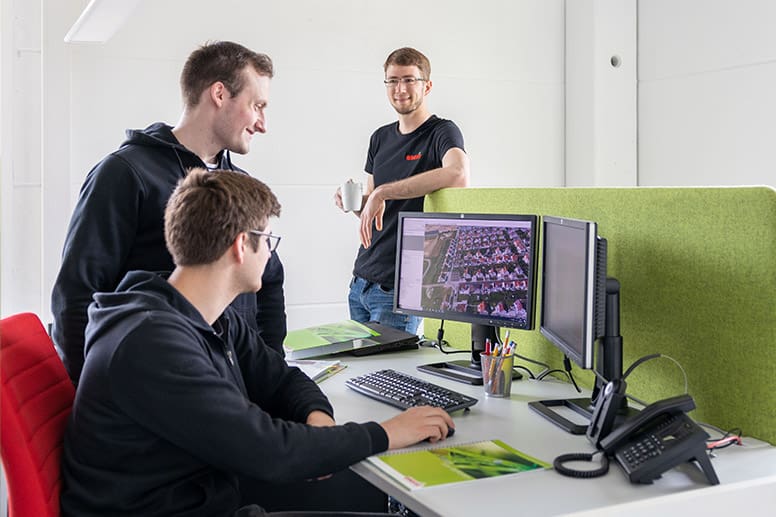 Technische Vertriebler von enerix schauen auf einen Monitor und planen eine PV-Anlage