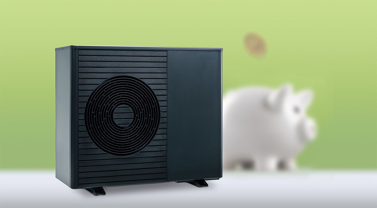 Eine schwarze Wärmepumpe auf grünem Hintergrund, ein Sparschwein mit einer Münze ist zu sehen.