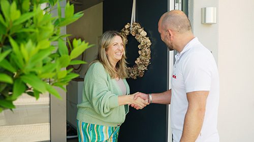 Dert Geschäftsinhaber von enerix Spessart wird von einer Kundin begrüßt vor ihrer Haustüre.