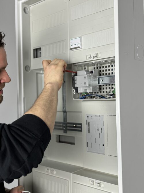 Ein Elektriker arbeitet an einem Stromkasten