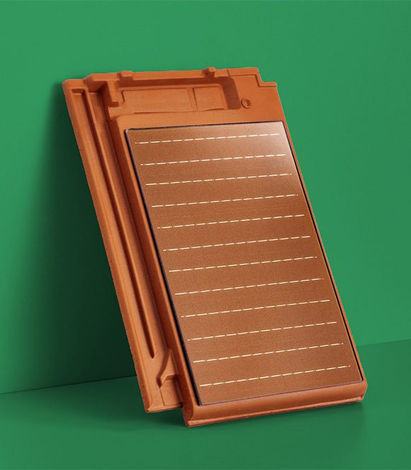 Ein Solardachziegel der an einer grünen Wand lehnt