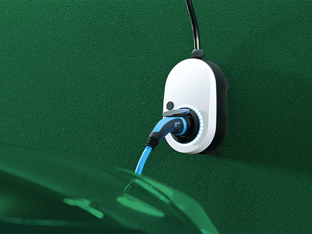 Eine Wallbox mit Kabel die an einer Wand hängt lädt ein Auto.