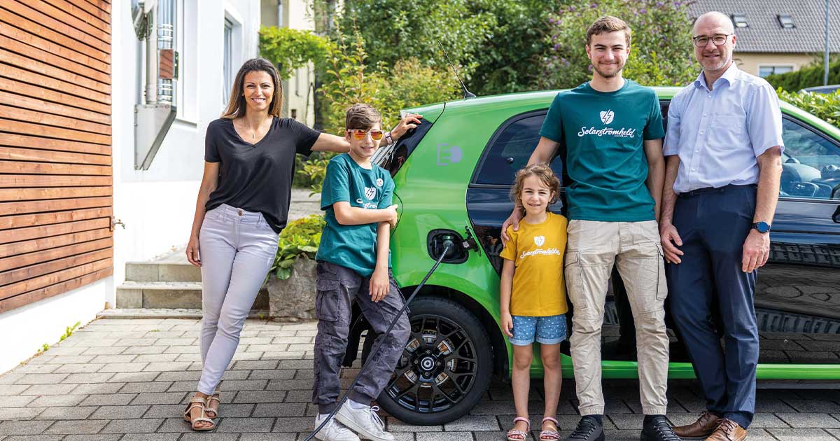 Eine Familie die vor einem eAuto steht und von dynamischen Netzentgelten profitiert