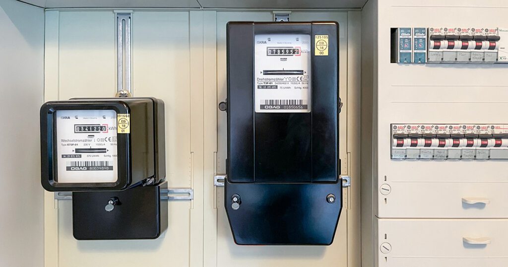 Klassische analoge Ferraris-Stromzähler in einem älteren Zählerschrank