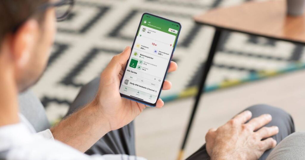 Ein Mann hält eine Smartphone mit der enerixControl App in der Hand
