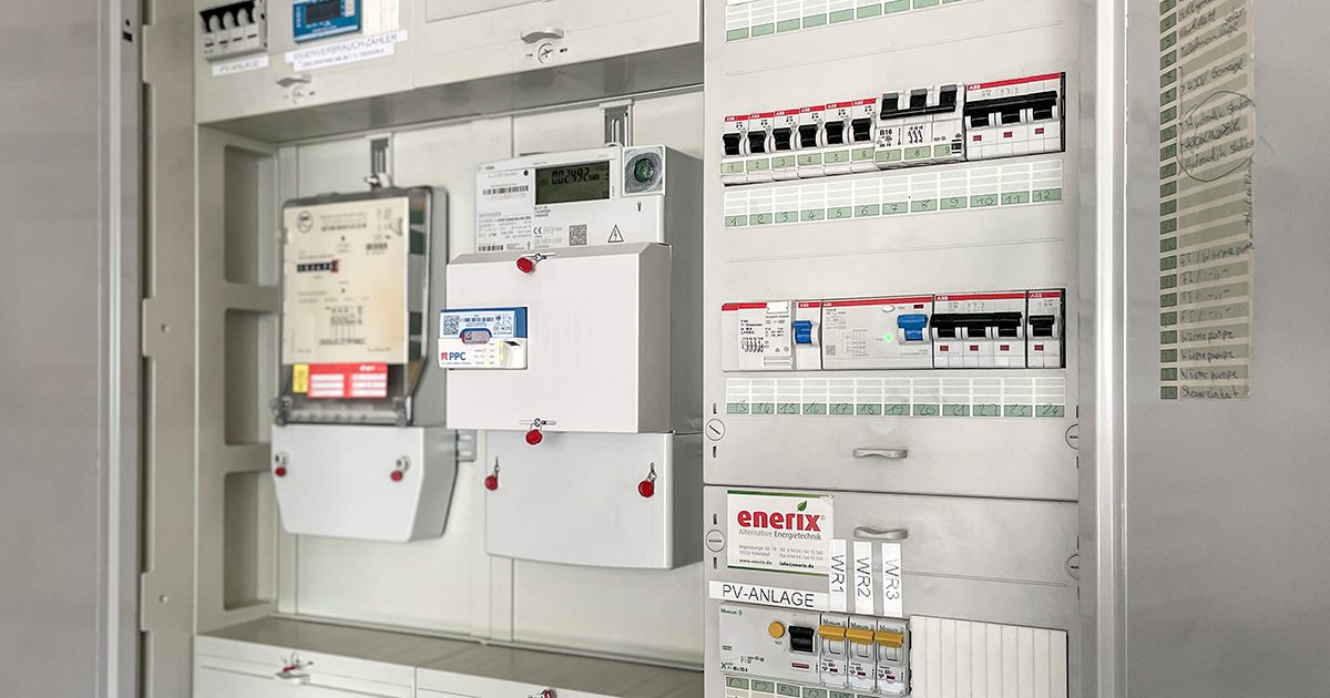 Detailaufnahme eines modernen Zählerschranks mit digitalen Stromzählern und Sicherungsmodulen.