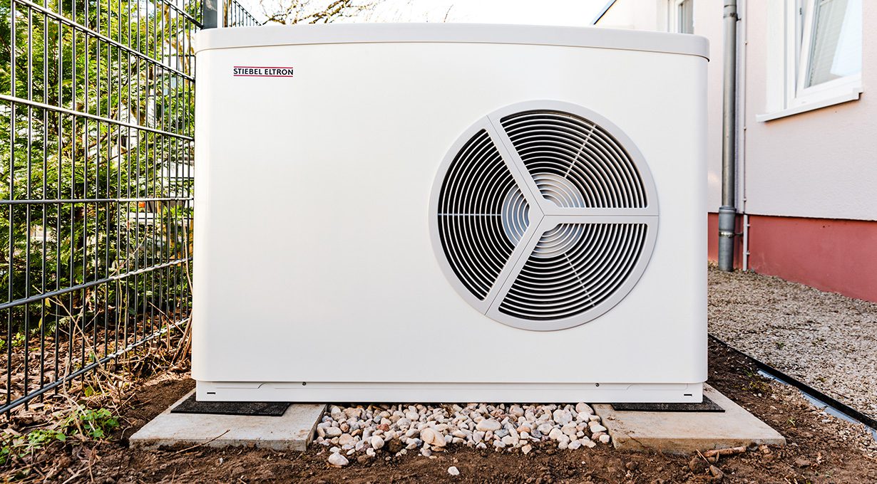 Eine Wärmepumpe die auf einem befestigten Fundament steht.