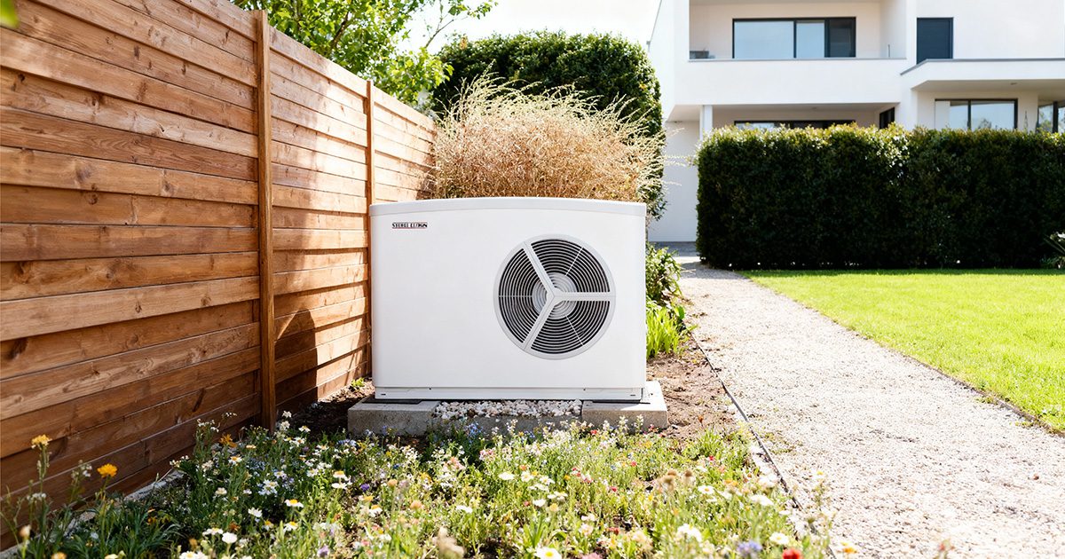 Eine Wärmepumpe im Sommer vor einem Haus