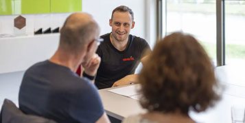 Eine enerix Berater berät eine Frau und einen Mann an einem Schreibtisch