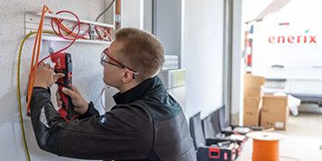 Ein enerix Techniker arbeitet an Kabeln in einer Garage