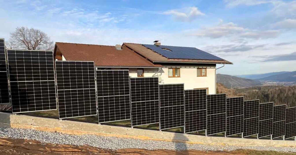 Ein Solarzaun an einer Straße vor einem Haus.